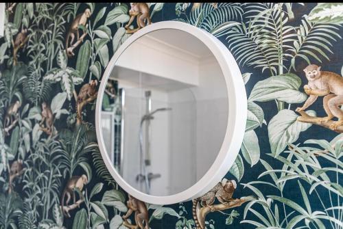 a mirror on a wall with a mural of plants at Sleek 2 Bedroom Apartment in Belfast