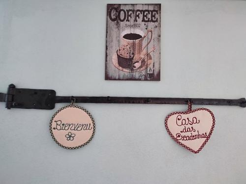 a wall with two hearts and a coffee sign and a picture at Casa das Escadinhas in Vale de Mendiz