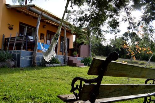 a bench in a yard in front of a house at Complejo Dulcería El Cazador y cabañas in Tandil