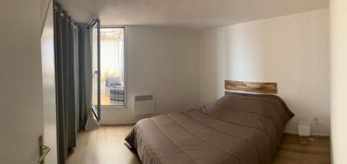 une chambre avec un lit dans une pièce avec une fenêtre dans l'établissement Appt 80 M2 VUE PORT - BAIGNOIRE BALNEO, à Gruissan