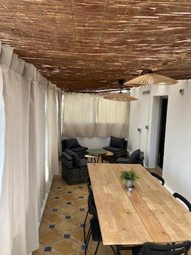 Cette chambre dispose d'une table en bois et d'un canapé. dans l'établissement Appt 80 M2 VUE PORT - BAIGNOIRE BALNEO, à Gruissan