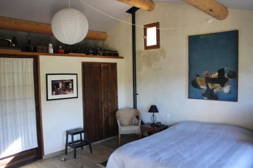 une chambre avec un lit et un tableau au mur dans l'établissement La maison basse, à Entrechaux