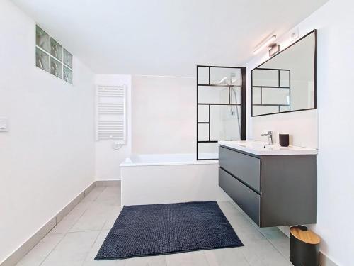 une salle de bain avec un lavabo, une baignoire et un miroir dans l'établissement Appartement Cosy en plein cœur du village, à Lorgues