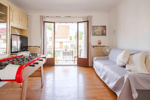 - un salon avec une table à jambe et un canapé dans l'établissement Villa Seine, à Bezons