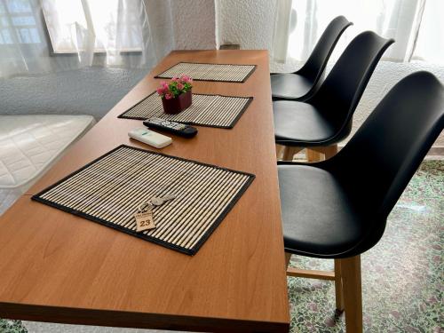 un tavolo di legno con quattro tovagliette sopra e delle sedie di PELEKAN rooms and apartments ATHINA 23 a Pefkohori