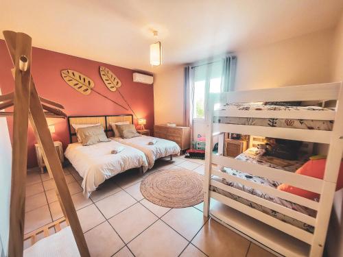 - une chambre avec deux lits superposés et un lit superposé dans l'établissement Au cœur des vignes, Villa Aramonie, Piscine privée, à Laurens