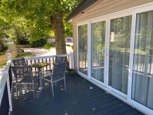 a screened porch with a table and chairs at Coghurst Hall Holiday Home Sleeps 6, 2 bedrooms in Hastings
