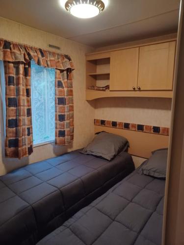 une chambre avec deux lits et une fenêtre dans l'établissement Etang de Peyrilhac, à Peyrilhac