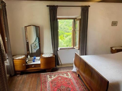 une chambre avec un lit, un miroir et une fenêtre dans l'établissement Charmante maison authentique et au calme, à Tavera