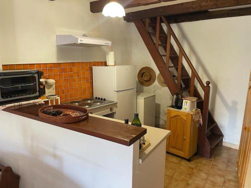 - une cuisine avec un comptoir et un réfrigérateur dans l'établissement Charmante maison authentique et au calme, à Tavera