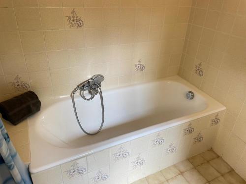 La salle de bains est pourvue d'une baignoire et d'une douche. dans l'établissement Charmante maison authentique et au calme, à Tavera