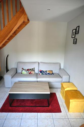 a living room with a couch and a table at Le duplex - studio - climatisé in Lons