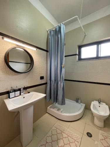 a bathroom with a sink and a toilet and a mirror at Casa Shpresë - The Traditional Suite in Tirana