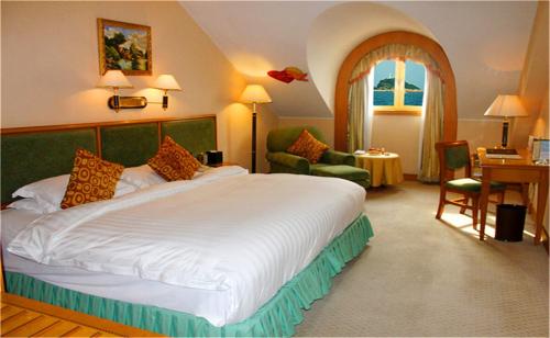 a hotel room with a large bed and a desk at Qingdao Oceanwide Elite Hotel in Qingdao