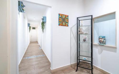a hallway with white walls and a mirror at RAUDINO ROOMS in Siracusa