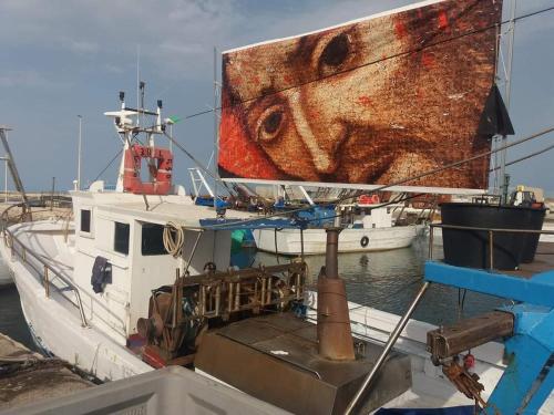 a boat with a painting of a fish on the side at Vista Mare Luxury Rooms & Apartments in Margherita di Savoia