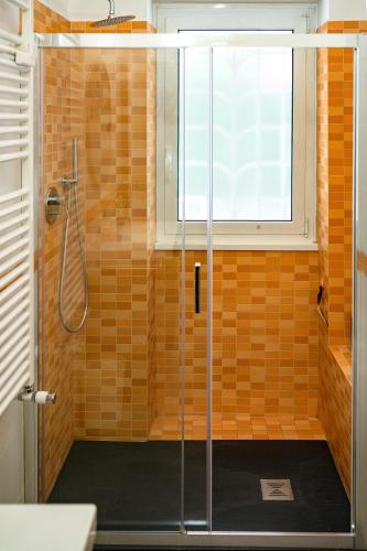 a shower with a glass door in a bathroom at Nido Azzurro Luxury House in Lido di Ostia