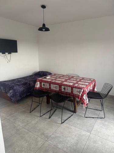 a room with a table and chairs and a bed at Super Departamento amplio y luminoso con cochera in Lanús