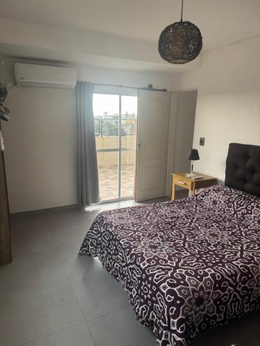 a bedroom with a bed and a sliding glass door at Super Departamento amplio y luminoso con cochera in Lanús