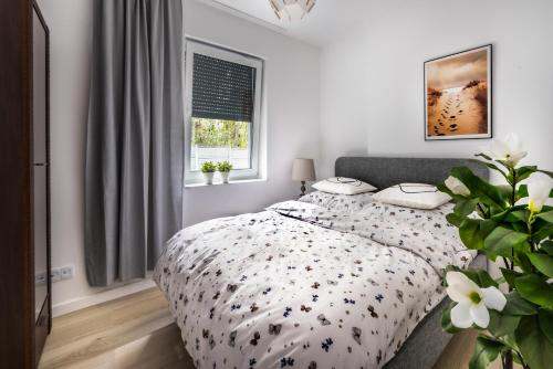 a bedroom with a bed with a black and white comforter at Apartament TU Cichowo in Cichowo