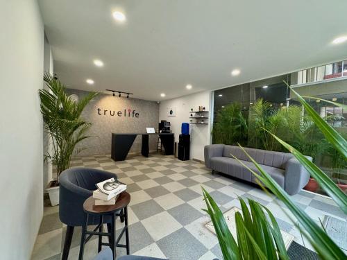 a lobby with a couch and a table and plants at Truelife Whitefield - Premium 1 BHK Apartments - Prime location - Easy access to Main Rd - Metro - ITPL - Fast WiFi - Kitchen - Smart TV - Power backup - Park - Garden views in Bengaluru