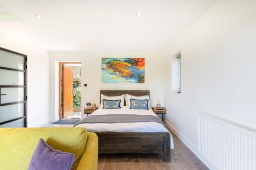 a bedroom with a bed and a yellow chair at Waterfield House B&B in Dorchester