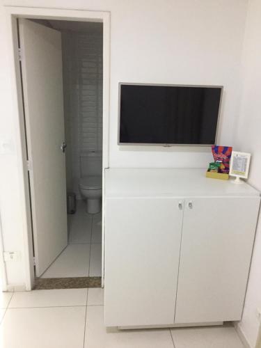 a bathroom with a television on a white cabinet at Pousada Lorde Inglês in Recife