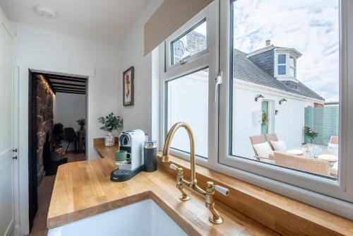 a kitchen with a sink and a large window at Keel Cottage & Dog Friendly in Nairn