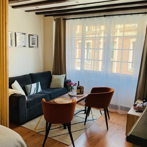 un salon avec un canapé bleu et des chaises dans l'établissement Studio chic de Sophie plein cœur du centre-ville, à Honfleur