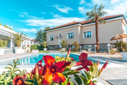 a villa with a swimming pool and palm trees at Villa Marchese Lake Maggiore in Somma Lombardo