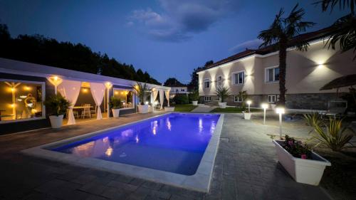 a swimming pool in front of a house at night at Villa Marchese Lake Maggiore in Somma Lombardo