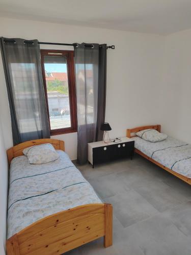 une chambre avec deux lits et une fenêtre dans l'établissement Joli appartement F3 proche transport, à Vénissieux
