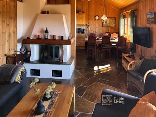 a living room with a fireplace and a dining room at Large cabin at Sjusjøen with sauna, fireplace, view and cross-country skiing in Ringsaker