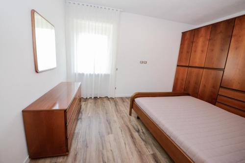 a bedroom with a bed and a wooden dresser at Domus Garda Relax in Garda