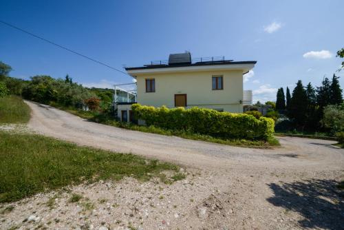 a house on the side of a dirt road at Domus Garda Relax in Garda