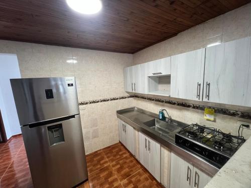 a kitchen with a stainless steel refrigerator and a sink at Amplio Apartamento con Vistas en Dosquebradas in Dosquebradas