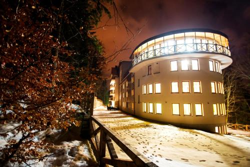 a building with a dome on top of it in the snow at Hotel EUROPA - Górnicza Strzecha in Szklarska Poręba