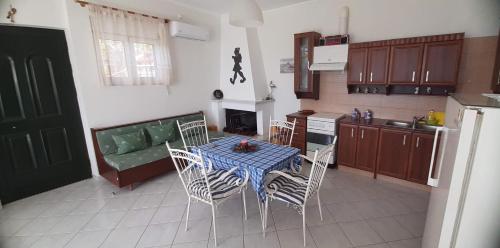 a kitchen with a table and chairs and a couch at OYRANIA -Μαυροβούνι Γυθείου- Σπίτι με θέα in Mavrovoúnion