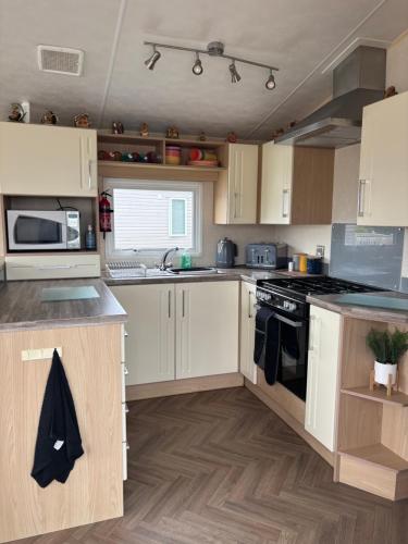 a kitchen with white cabinets and a stove top oven at Nockys nook in Filey