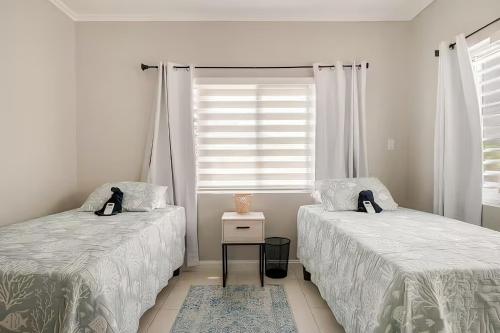 a bedroom with two beds and a window at Ocho Rios Ocean Escape in Richmond