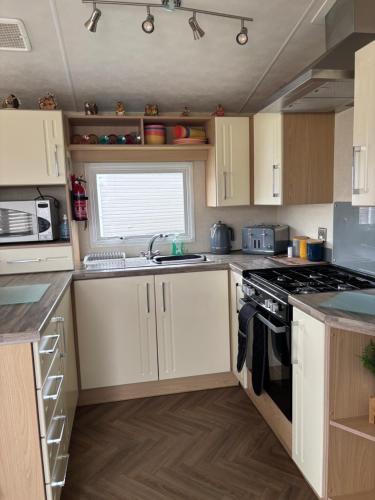 a kitchen with white cabinets and a stove top oven at Nockys nook in Filey