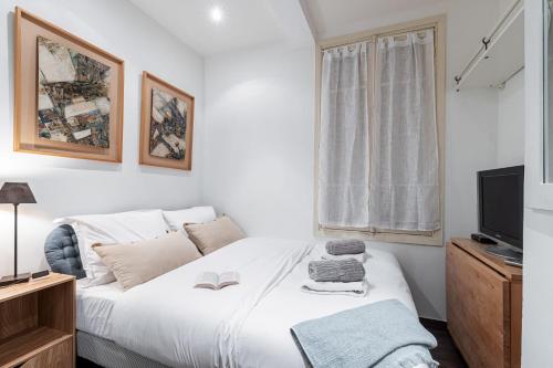 une chambre avec un lit blanc et une télévision dans l'établissement STALINGRAD 32 - Cosy Apartement close old Port, à Nice