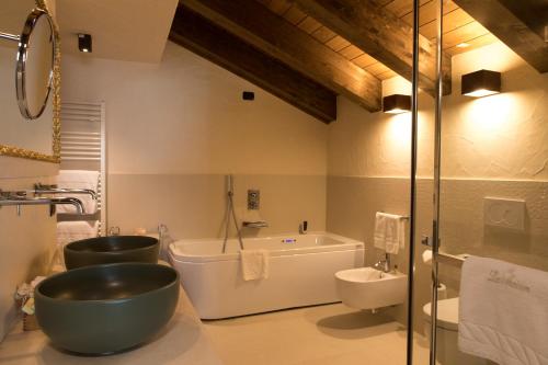 a bathroom with a large bowl sink and a bath tub at Auberge de La Maison in Courmayeur