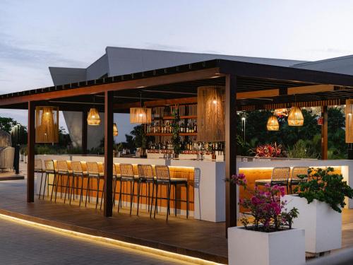 a restaurant with a bar with chairs and lights at Grand Sirenis Riviera Maya Resort & Spa All Inclusive in Akumal