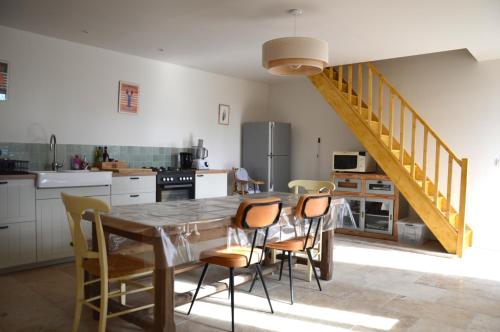 une cuisine avec une table et des chaises en bois dans l'établissement Maison de charme, jardin, 5km plage, côte d'Emeraude, à Plévenon