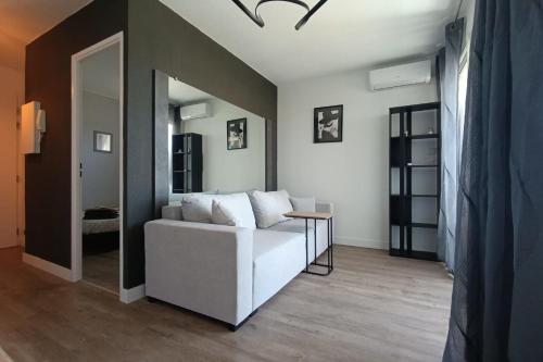 un salon avec un canapé blanc et une table dans l'établissement Naturiste Cap d'Agde Natura Beach 113, au Cap d'Agde