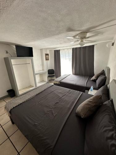 a bedroom with a large bed and a window at Hotel Posada Jardín Aguascalientes in Aguascalientes