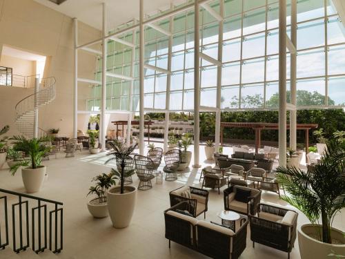 a lobby with a lot of chairs and plants at Grand Sirenis Riviera Maya Resort & Spa All Inclusive in Akumal