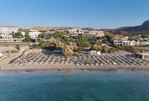 an aerial view of a beach with chairs and buildings at Kiotari Bay in Kiotari