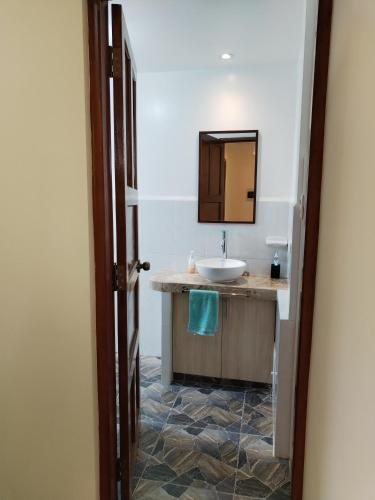 a bathroom with a sink and a mirror at Apu Tacllo lodge in Layo